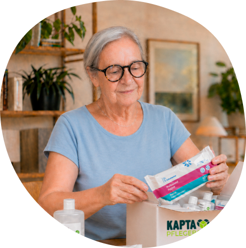 Seniorin packt zufrieden ihre KAPTA Pflegebox aus